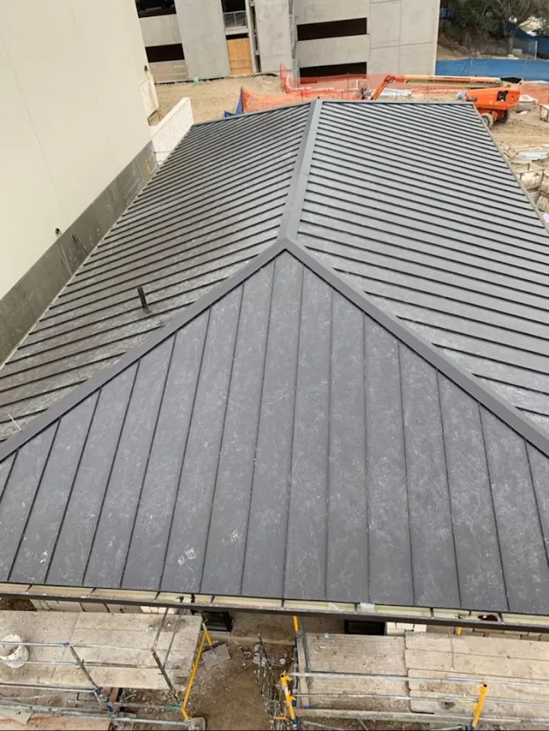 Commercial metal roof construction with crane equipment in Chula Vista